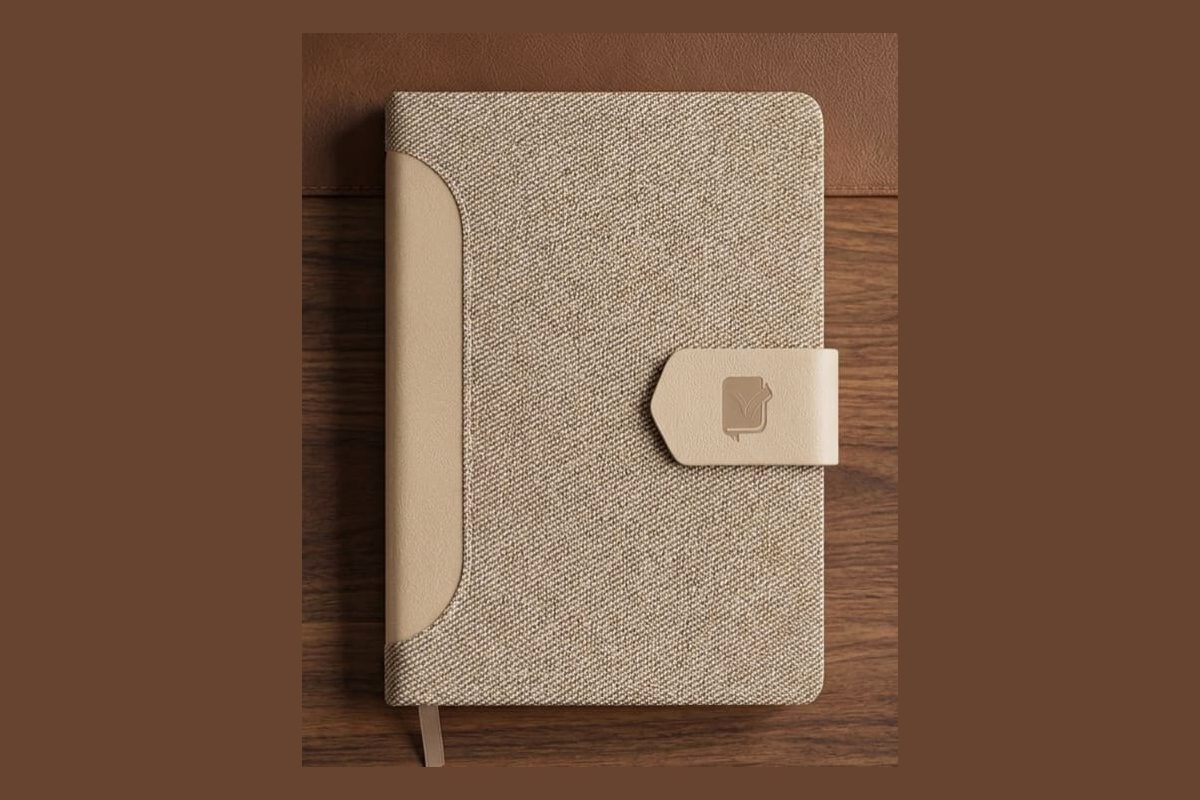 Close-up of a natural textile notebook cover showing a debossed branding area
